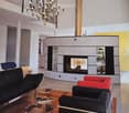 modern interior design, fireplace, chandelier, leather couches, glass coffee table