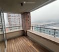 Wooden deck balcony with modern railing, overlooking cityscape with buildings and foggy skyline.