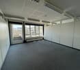 empty room, fluorescent ceiling lights, glass door, large windows, gray floor
