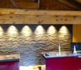 Interior with wooden beams, red cabinets, granite tiled wall, grey laminate floor.