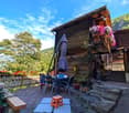 wooden chalet, balcony, patio table, flowers, view of the mountains