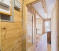 wooden walls, wooden floor, small hallway leading to two rooms