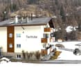 3 story building, white and brown exterior, multiple balconies, snow covered ground