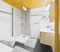 modern bathroom with white tiles, glass shower, white sink, white toilet, wooden ceiling