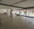empty room with sliding glass doors, chairs, tables, person walking outside