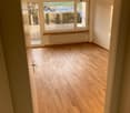 empty room, wooden floor, large windows, view, white walls, radiator