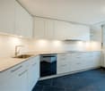 modern kitchen, white cabinets, granite countertops, stainless steel sink, dishwasher, built-in oven, under cabinet lighting