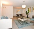modern open plan living room with dining area, tile flooring, white sofa, coffee table, plants, table, chairs