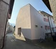 Corner residential building with a car entrance in the back