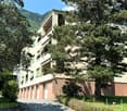 A building with 4 garages at the entrance, balconies on each floor, and several windows