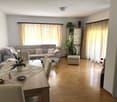 modern design, large windows, dining table, 4 chairs, gray couch, coffee table, plants, open doors