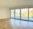 wooden floors, large glass sliding doors to a terrace, white walls, view of mountains and town