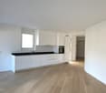white cabinets, black counter, wooden floor, window, sink, oven
