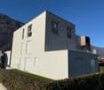 white exterior, large windows, balcony, mountain view