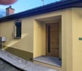 single-family house, yellow wall, brown wooden door, small mailbox, brick chimney