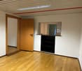 empty room, wooden floor, white walls, wooden door, small window, built-in shelf