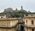 Old buildings with balconies, a castle on a hill, narrow street