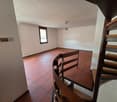 empty room, red tiles, white walls, spiral staircase, window