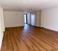 empty room with hardwood floors, white walls, built-in closets, small balcony