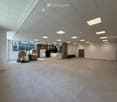 large open space, tiled floor, white walls, ceiling with recessed lighting, large windows, staircase, storage boxes