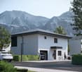 Detached house, white exterior, modern architecture, gray roof, garage, lush greenery, mountain view