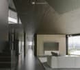Long hallway, glass wall, white sofa, large windows, staircase