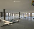 Empty room, multiple windows, high ceiling, construction materials scattered on the floor