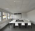 empty room, white walls, white ceiling, white tables, white chairs, projector screen, windows