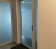 tiled floor, glass door, black mat, white wall, switch