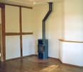 empty room, fireplace, wooden floor, white walls, wooden beams