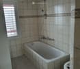 Bathroom. Bathroom with a bathtub, shower head, faucet, and toilet.