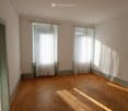 Parquet flooring, white walls, windows with white curtains, radiators