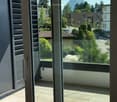 Balcony with tiled floor, large glass doors, and scenic mountain view.