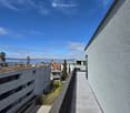 Balcony / Terrace. Balcony overlooking a residential area with buildings, greenery, and a body of water in the distance.