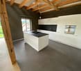 Kitchen. Modern kitchen with island, white cabinets, black countertops, and tiled floor.