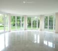 Empty room with large windows, white walls, and a polished tile floor. No furniture or equipment is present.