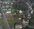 Aerial view of a residential area with multiple buildings, roads, and green spaces.
