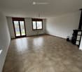Empty room with tiled floor, large window, and sliding glass door leading outside.