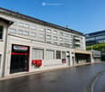 Multi-story building with a storefront labeled "VELO PLUS" and a modern glass facade in the background.
