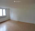 Empty room with wooden flooring, white walls, and a window with white frames. No furniture or equipment present.