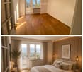 Modern, well-lit bedroom with wooden flooring, large windows offering a scenic view, a neatly made bed with pillows and a blanket, nightstands with lamps, a framed picture on the wall, and decorative plants.