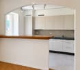 Modern kitchen with white cabinets, wooden countertop, sink, and tiled floor.