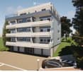 Modern multi-story apartment building with balconies, parking area, and landscaped surroundings.