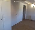 Empty room with wooden flooring, white walls, a radiator, and a closet. No furniture or equipment present.