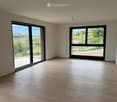 Empty room with wooden flooring, large windows, and a view of a vineyard and countryside.