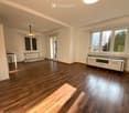 Wooden floor, two windows, a sliding door, ceiling lamp, an entertainment center, wooden furniture, daylight