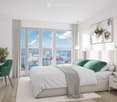 Modern bedroom with a large bed, nightstand, green chair, desk, and large windows offering a city view.