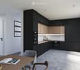 Modern kitchen with black and wood cabinets, stainless steel appliances, a wooden dining table with chairs, and a pendant light fixture.