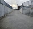 Empty concrete road, with concrete walls on both sides, and railings.