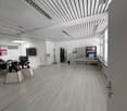 large open space, white walls, wooden floor, glass wall, table, chairs, fan, shelves, file cabinet, television